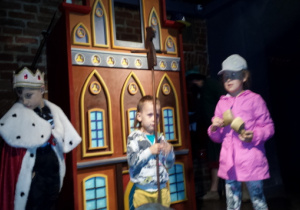 Dzieci uczestniczą w przedstawieniu w Domu Legend Toruńskich.